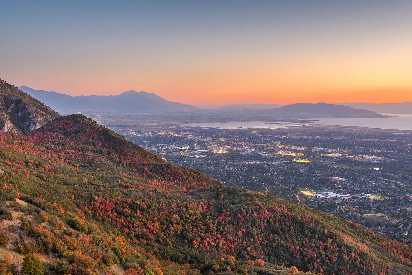 Autumn mountainside overlooking Salt Lake Valley at sunset with distant lake