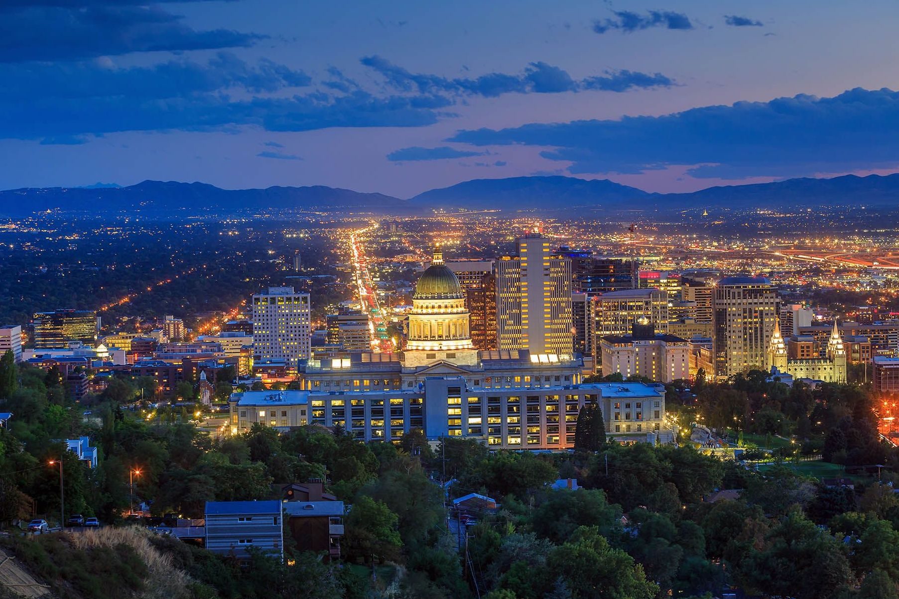 Salt Lake City skyline at dusk with Utah State Capitol and mountain backdrop